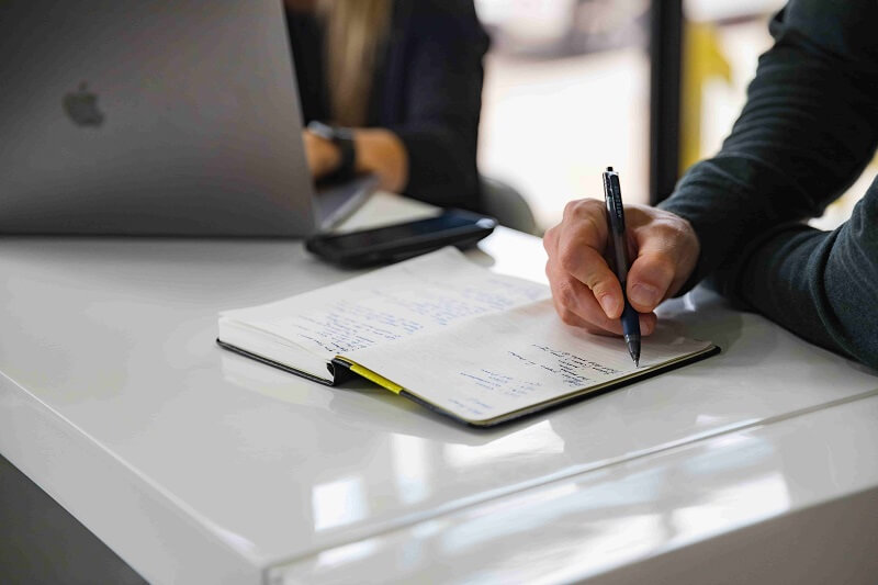 a man writing down password in a notebook