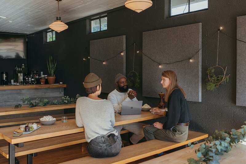 three people sitting in a cafe, discussing an alternative to Sticky Password