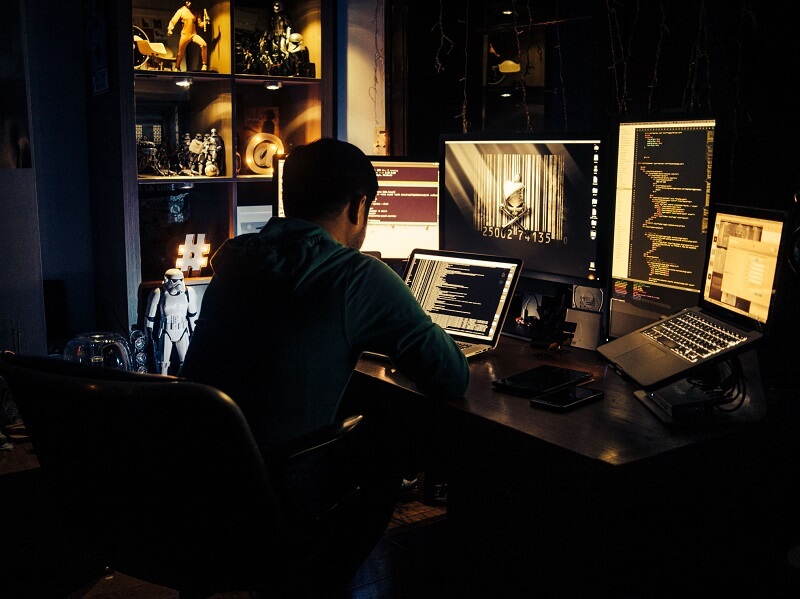 a man sitting in the dark room studies the biggest data breaches in 2022