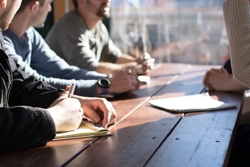 people sitting at the table, discussing the possibilities of a supply chain attack